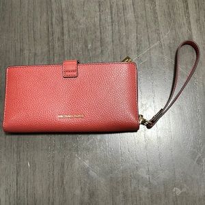 A real authentic Michael kors purse in the color red.